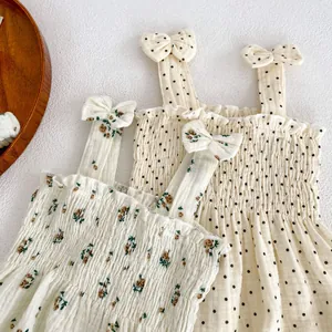 Detail of floral and polka dot baby rompers with ruffled texture and bow straps