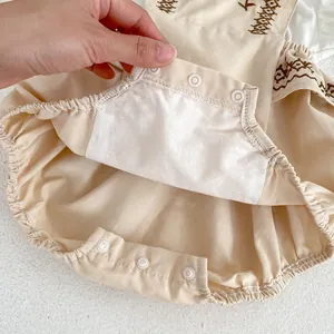 Detailed view of baby romper featuring snap buttons at crotch and ethnic embroidery detail