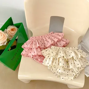Detail showing pink and beige ruffled diaper covers with black polka dots and elastic waist