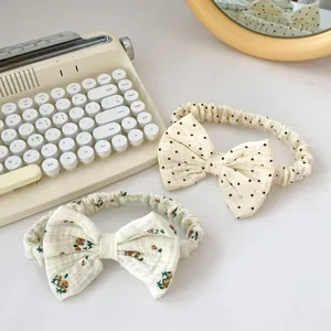 Detail of two floral and polka dot baby bow headbands with soft elastic cotton fabric