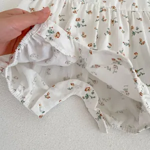 Détail d'une barboteuse à fleurs pour bébé avec boutons-pression et texture en coton