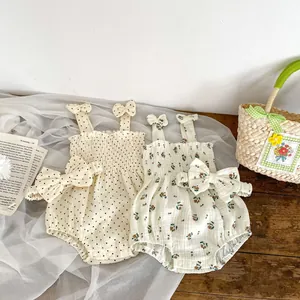 Detail of floral and polka dot cotton baby rompers with matching bow headbands
