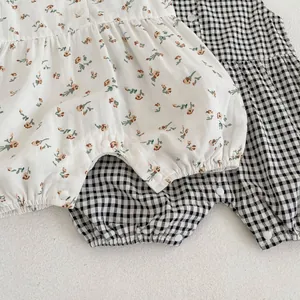Détail de barboteuses pour bébé à motifs floraux et vichy avec volants à la taille