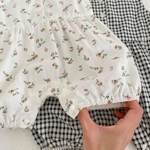 Détail d'un barboteuse pour bébé avec fleurs et carreaux montrant les poignets élastiques