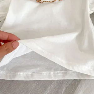 Detailed close-up of double-stitched hem and cotton fabric texture on baby romper