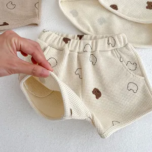 Detailed view of baby waffle knit shorts featuring bear prints and soft elastic waistband