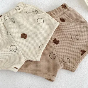 Detail of waffle cotton baby shorts with elastic waist and cute brown bear patterns