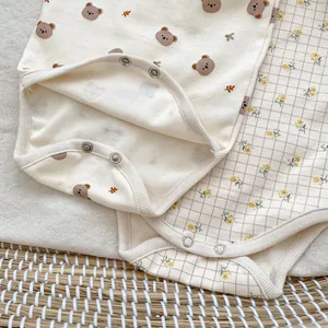 Detail of baby bodysuits showing soft cotton fabric and durable metal snap buttons