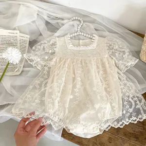 Pagliaccetto in pizzo crema per neonata con ricami floreali e maniche in tulle