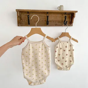 Detail of infant bodysuits featuring floral gingham and bear patterns with snap buttons
