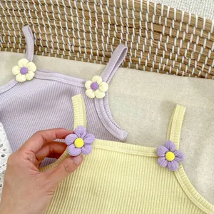 Detalle del conjunto de camiseta de tirantes de punto acanalado con flores de tela para bebé