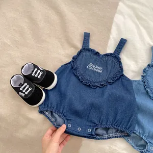 Detail of baby denim romper with heart ruffle embroidery and snap closure