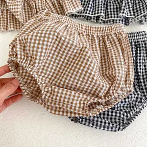 Detail of infant plaid bloomers showing elastic waistband and soft cotton fabric texture