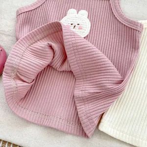 Close-up of pink ribbed baby tank top featuring a handcrafted knitted bunny patch detail