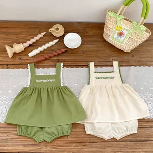 Detailed flat lay of baby girl cotton sets with floral embroidery and lace trim finish