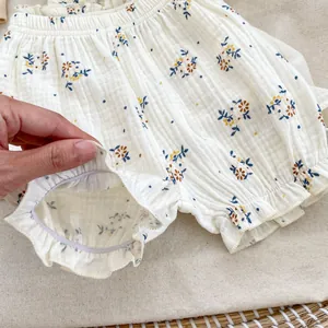 Dettaglio dei polsini elasticizzati con volant su pantaloncini a fiori per neonata