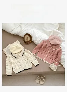 Detail of baby cotton knit cardigans with hollow weave and scalloped collar texture