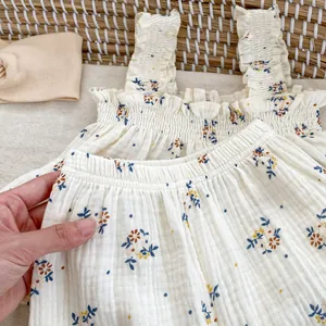 Dettaglio del set neonata in cotone a fiori con spalline a volant e pantaloncini