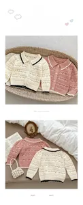Detailed knit pattern on a toddler cardigan featuring hollow-out lace and buttons