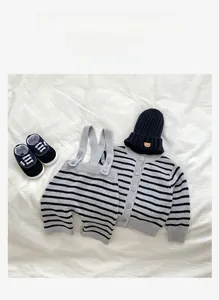 Detailed flat lay of baby knit set featuring striped cardigan and bear patch hat