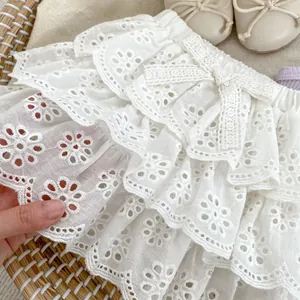 Detalle de falda blanca de encaje de algodón para bebé con bordados en una cesta