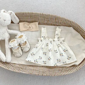 Vista piatta del top a fiori per neonata con fascia a fiocco e scarpe di pizzo in un cesto