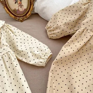 Detail of baby corduroy rompers with polka dots and elastic cuffs in neutral tones