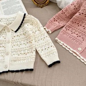 Detailed close-up of hollow crochet knit texture and scalloped edges on toddler sweaters
