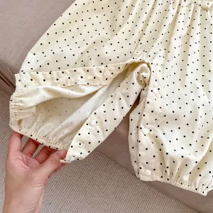 Detail of snap button closure and polka dot pattern on corduroy baby romper