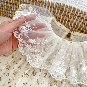 Detail of baby floral bodysuit with delicate white lace collar and flower embroidery