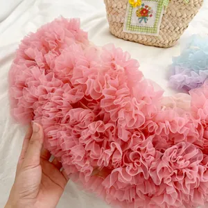 Detail of layered pleated tulle ruffles in pink, blue, and purple for girls' outfits