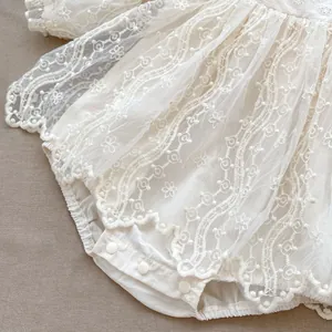 Dettagli della tutina in pizzo per neonati con ricami floreali e bottoni a pressione
