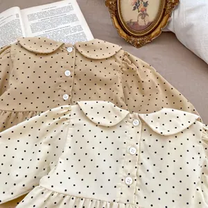 Detailed view of polka dot baby rompers with Peter Pan collars in khaki and beige