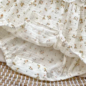 Macro view of floral baby bodysuit featuring breathable wrinkled cotton and white snap buttons
