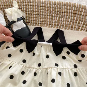 Toddler girl polka dot dress with black bow straps and matching Mary Jane shoes