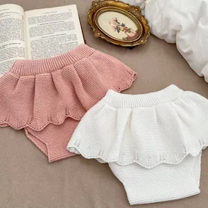 Gebreid tweedelig setje voor meisjes met roze en witte rokbroek met ruches en trui