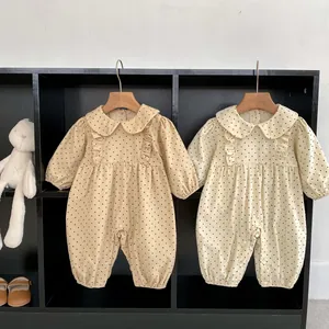 Detail of infant corduroy bodysuits with polka dots and ruffled Peter Pan collar