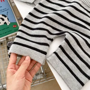 Close-up of flexible ribbed cuffs on a striped baby knit sweater showing soft fabric texture