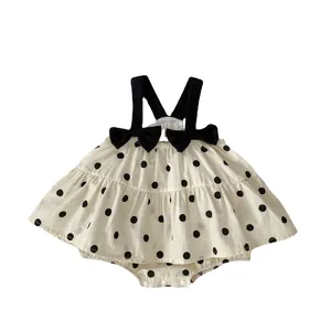 Baby girl polka dot bodysuit dress with shoulder bows and snap buttons on white background