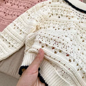 Detailed view of the hollow pointelle knitting pattern on baby girl's cardigan