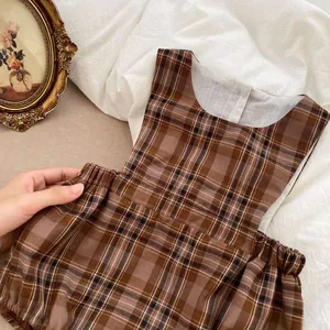 Détail d'un barboteuse à carreaux pour bébé montrant le tissu respirant et la taille élastique