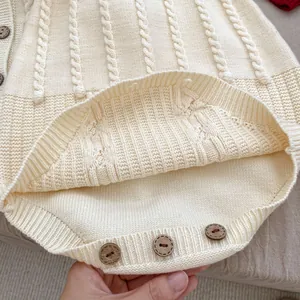 Detailed cable knit texture and wooden buttons on cream baby knit bodysuit