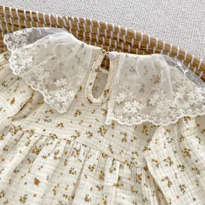 Detail of baby floral romper featuring lace collar and textured fabric in a basket