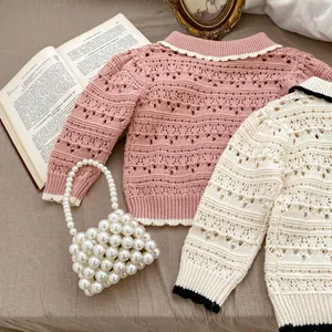 Detail of hollow-out knit cardigans for baby girls in pink and cream with vintage collars