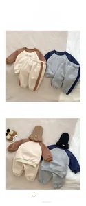 Detail of fleece-lined cotton tracksuits with letter embroidery and side stripes