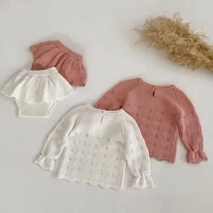 Detail van gebreide textuur en golfpatroon van het baby meisje gebreide kledingsetje