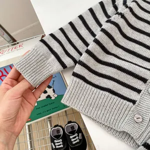 Detail of ribbed cuffs and soft striped knit texture on infant cardigan sweater