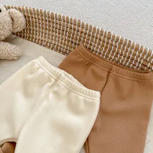 Detailed close-up of ribbed cotton baby leggings with elastic waist in cream and brown
