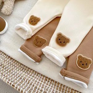 Close-up of warm fleece lining and cute 3D bear embroidery on baby ribbed knit trousers