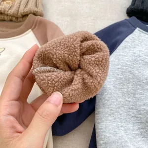 Detail of warm brown teddy fleece lining and contrast stitching on toddler sweatshirt